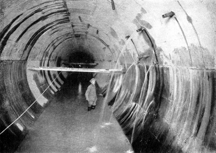 A historic black and white photo of a large aqueduct bridge under construction.